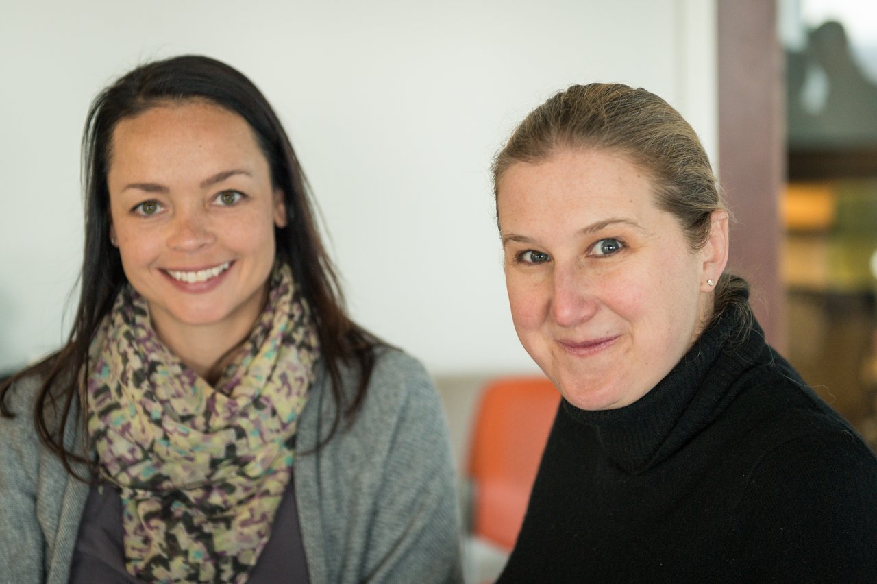 Two women smiling at the camera during the Acquia Executive Breakfast event in 2015.