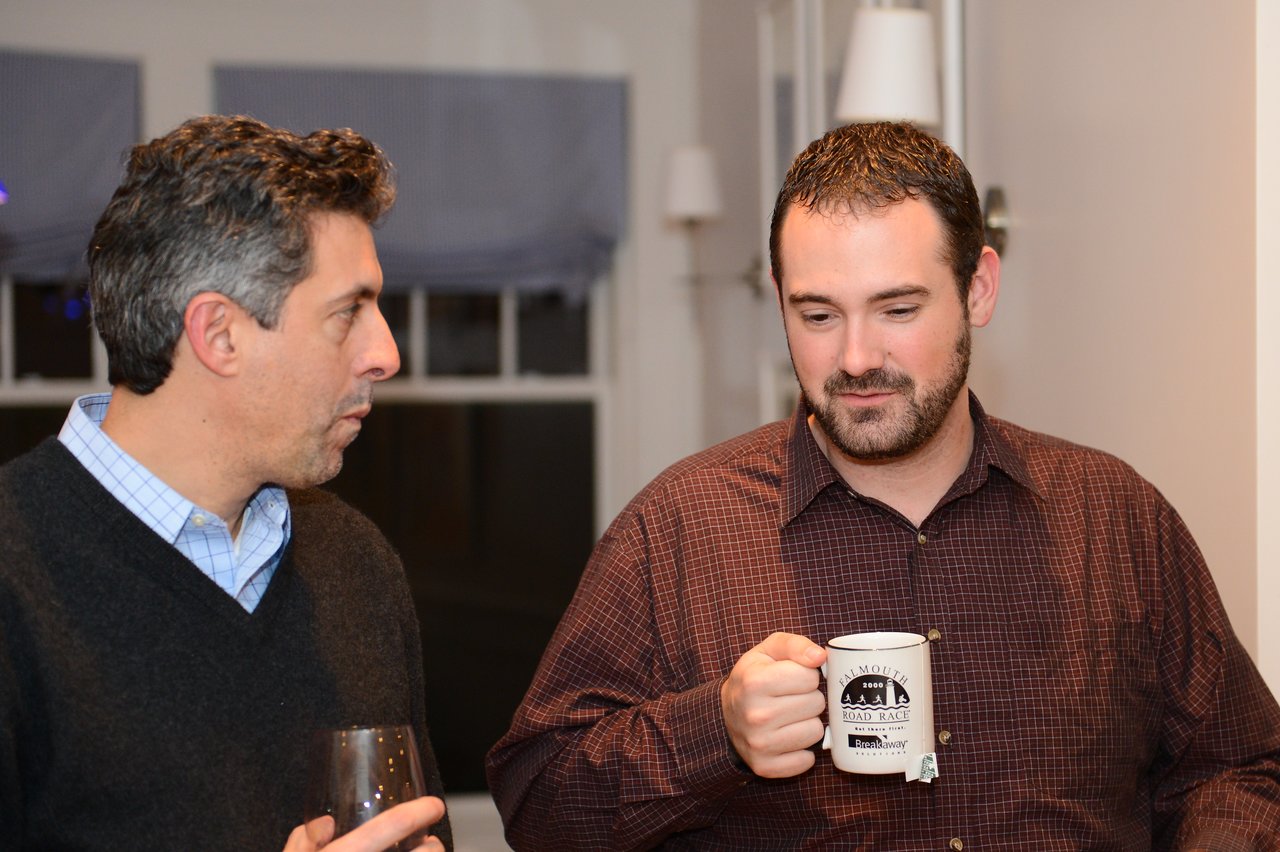 Two men are talking indoors.