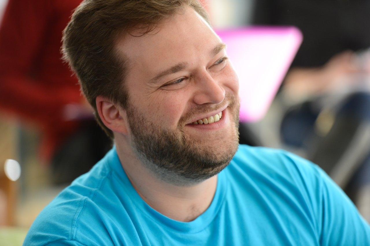 A smiling person in a bright blue shirt at an Acquia offsite event in October 2013.