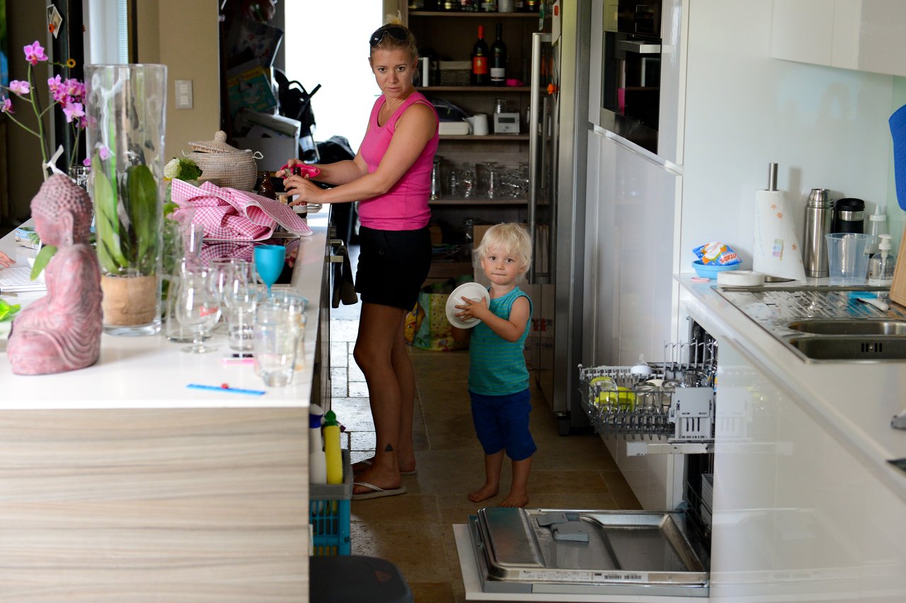A woman and a young child are in a kitchen.