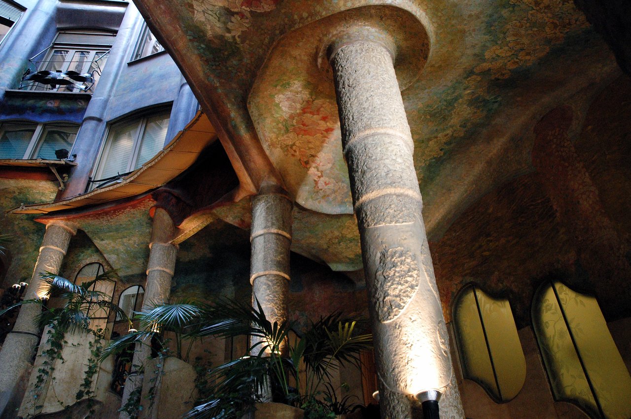 Stone columns and a decorated ceiling in the interior courtyard of La Pedrera, a famous building in Barcelona.