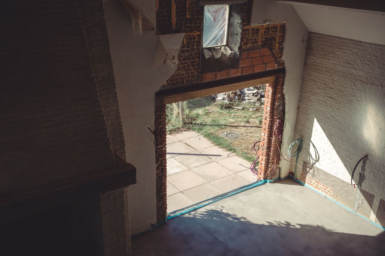 Partially constructed patio and kitchen area with sunlight streaming in through a large open doorway.
