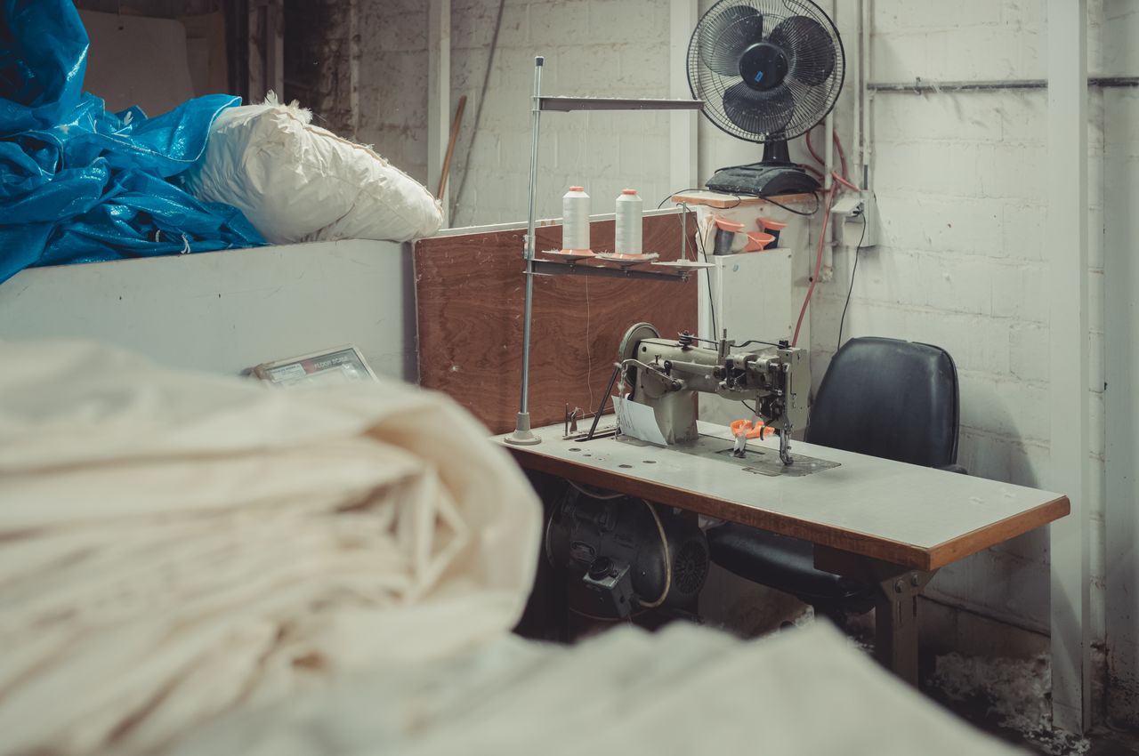 Industrial sewing machine, surrounded by goose down and fabrics.
