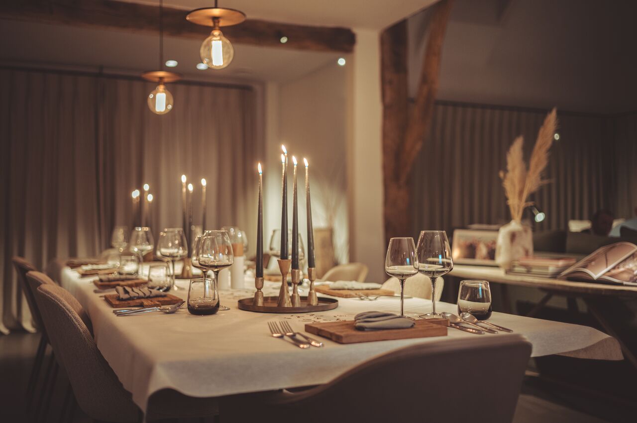 A beautifully set dinner table with candles and wine glasses.