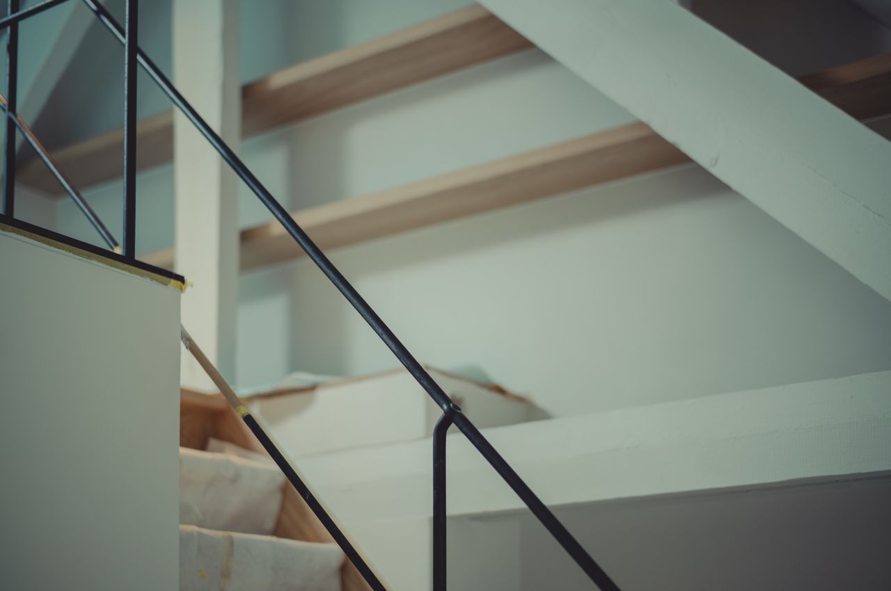 Closeup of staircase with black metal railing.