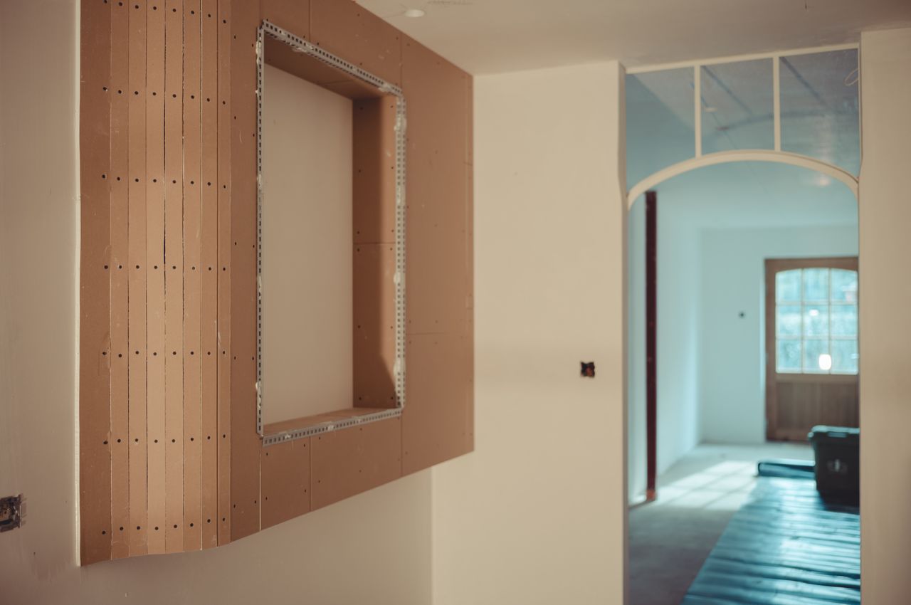 A rounded sheetrock cabinet hanging on a wall.