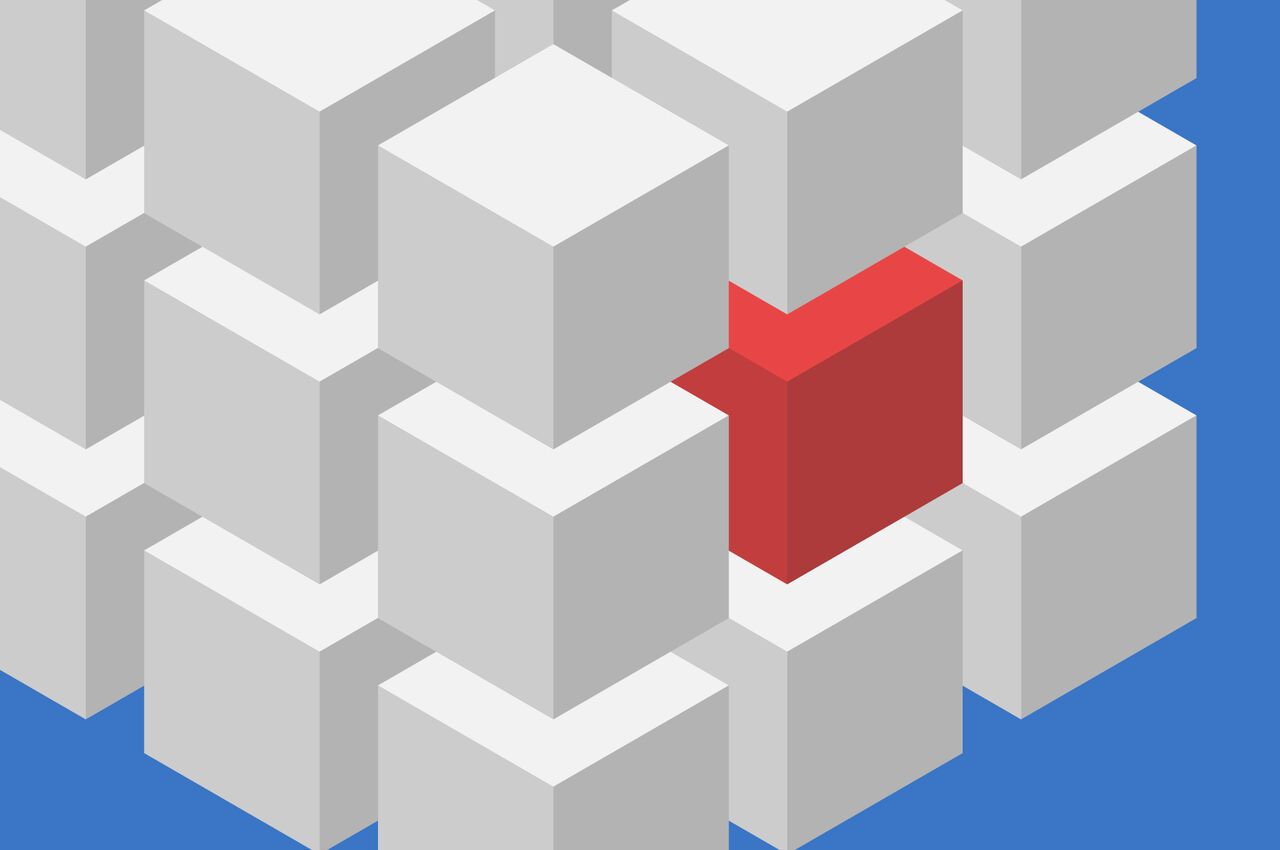 One red cube stands out in a grid of gray cubes.