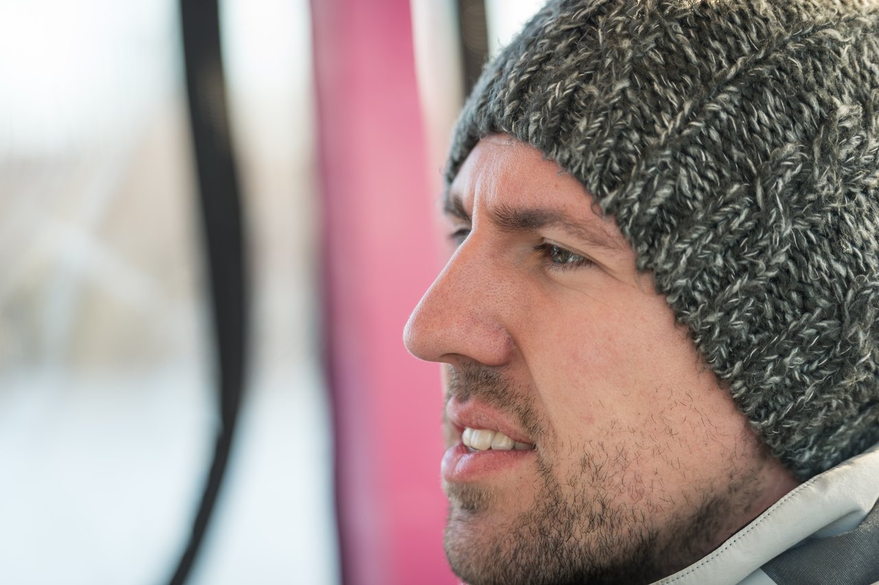 A man wearing a gray knit beanie looks out the window during a Boston Duck Tour.