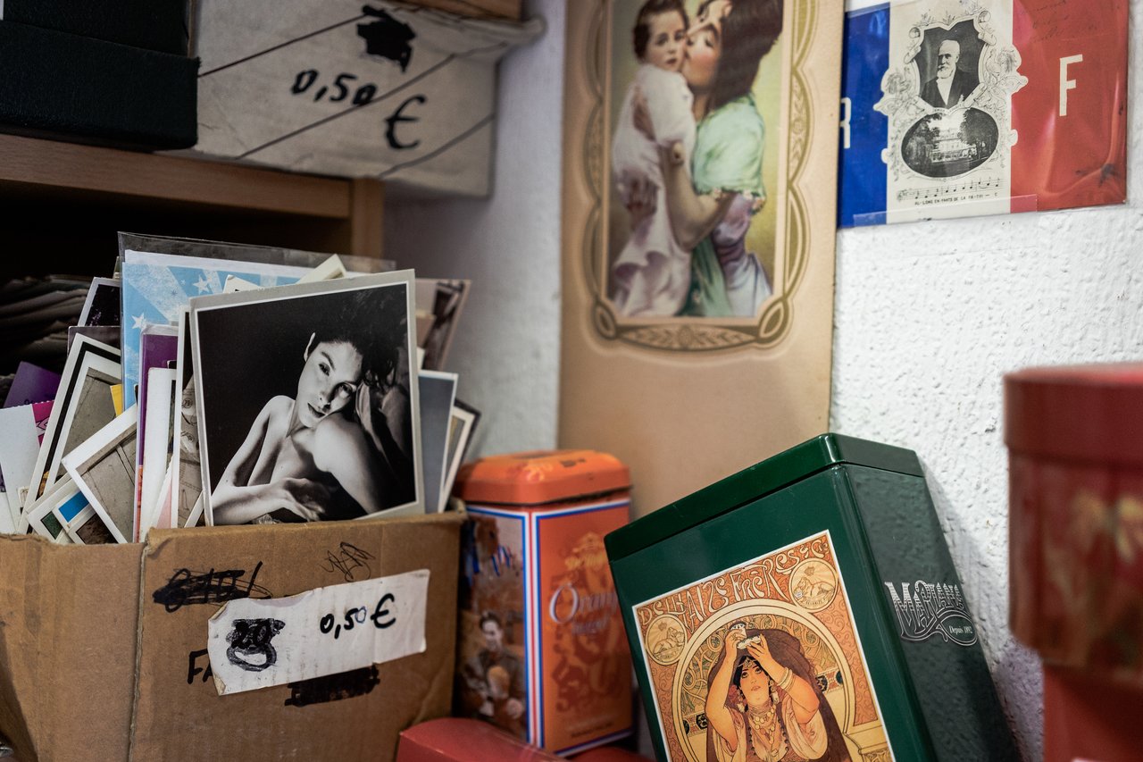 A cardboard box filled with old postcards and photographs, priced at 0.