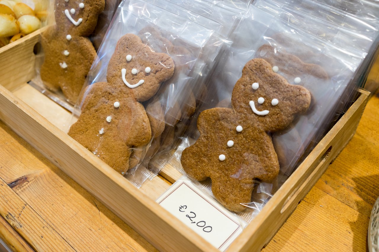 A wooden tray holds bear-shaped speculoos cookies with icing faces, individually wrapped in plastic, priced at €2.