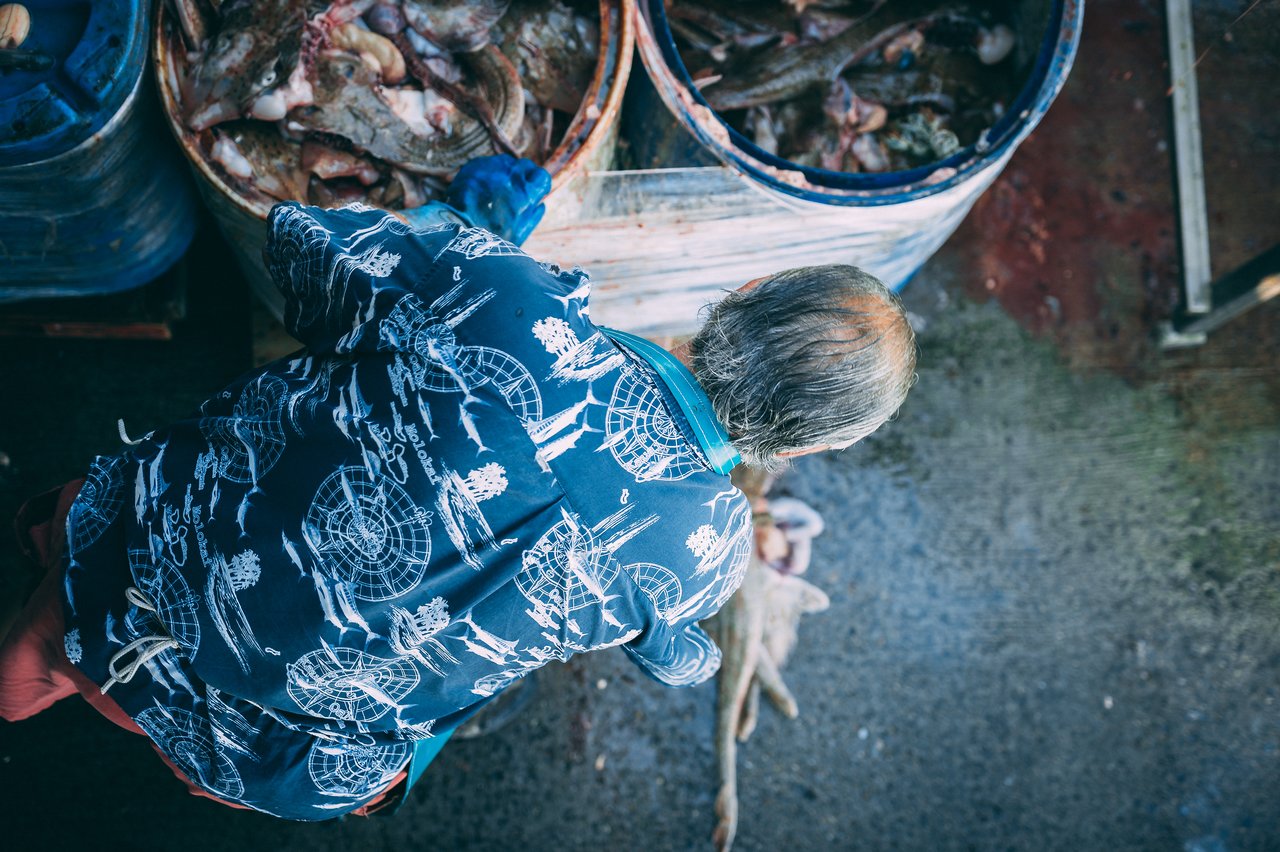 A worker unloads fish from a barrel at the Chatham Pier Fish Market.