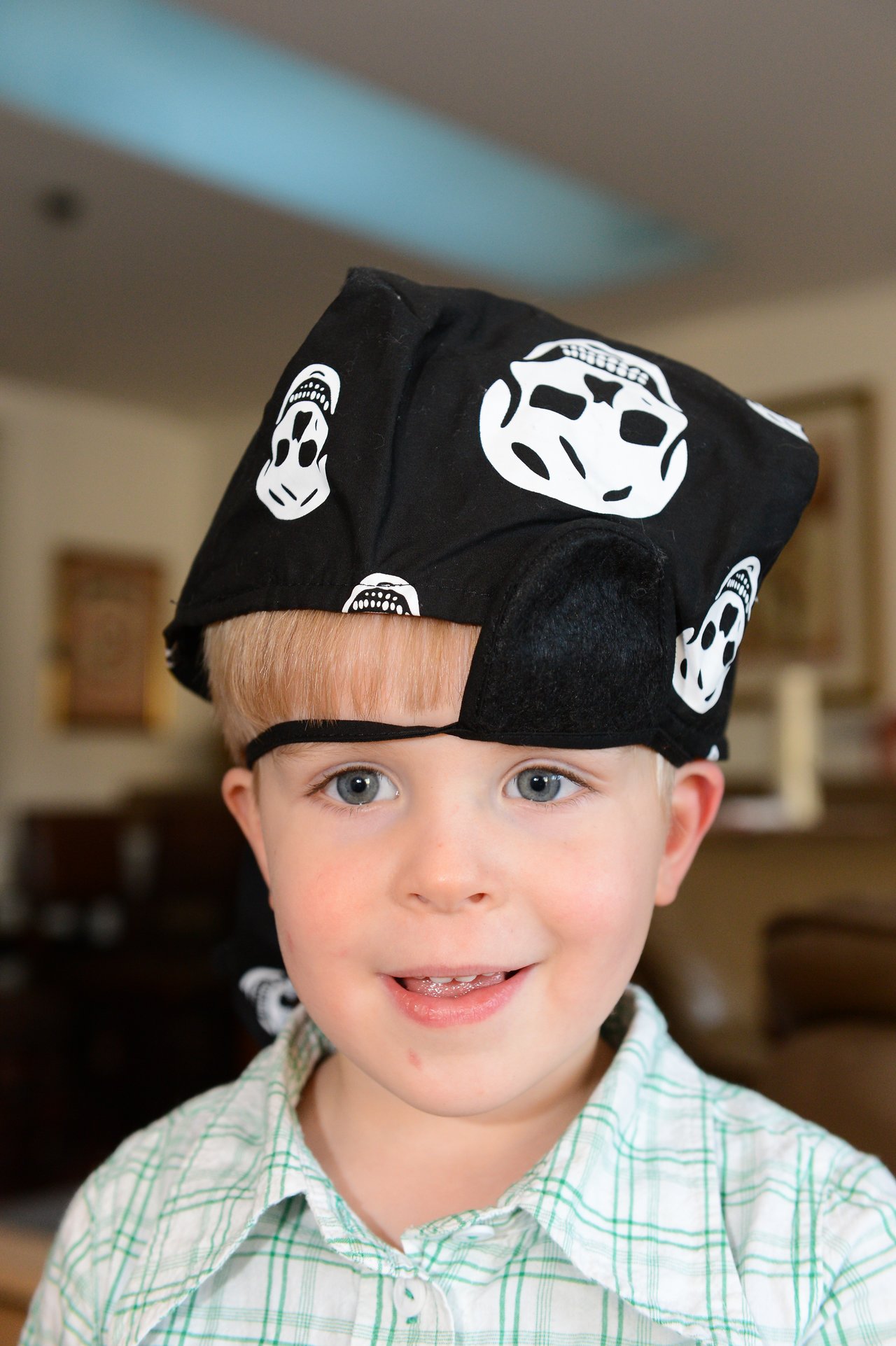 A young child wears a pirate-themed bandana and smiles at the camera.