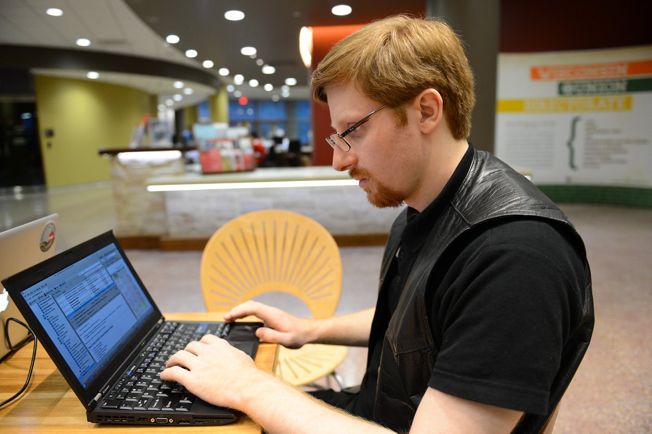A person types on a laptop at a table during the Drupal Developer Summit in Madison, 2012.