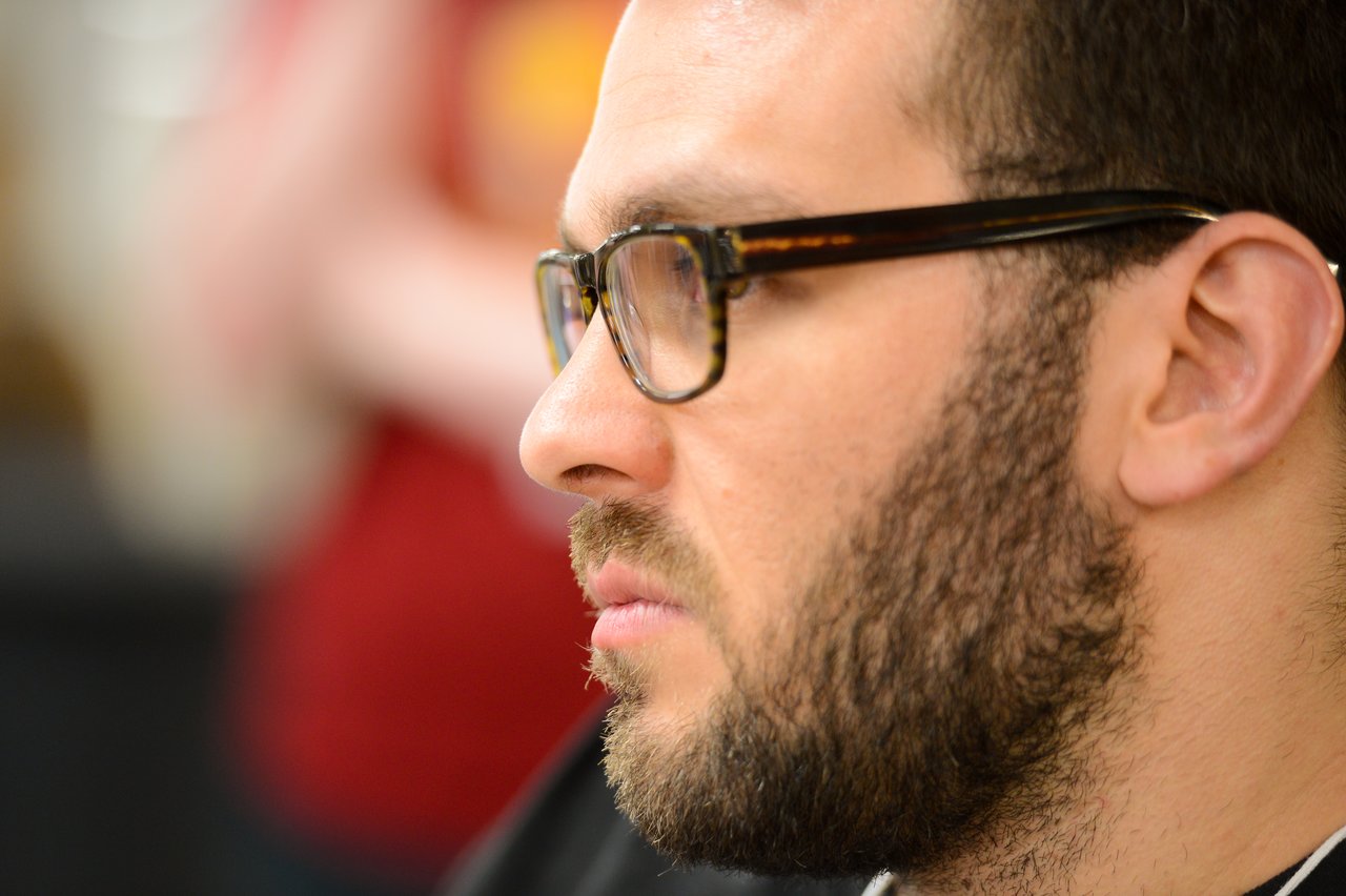A bearded man wearing glasses looks focused during a Drupal developer sprint.