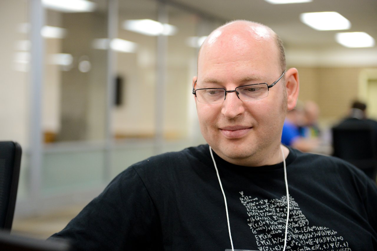 A person wearing glasses and a black shirt looks at a screen during a Drupal developer sprint.