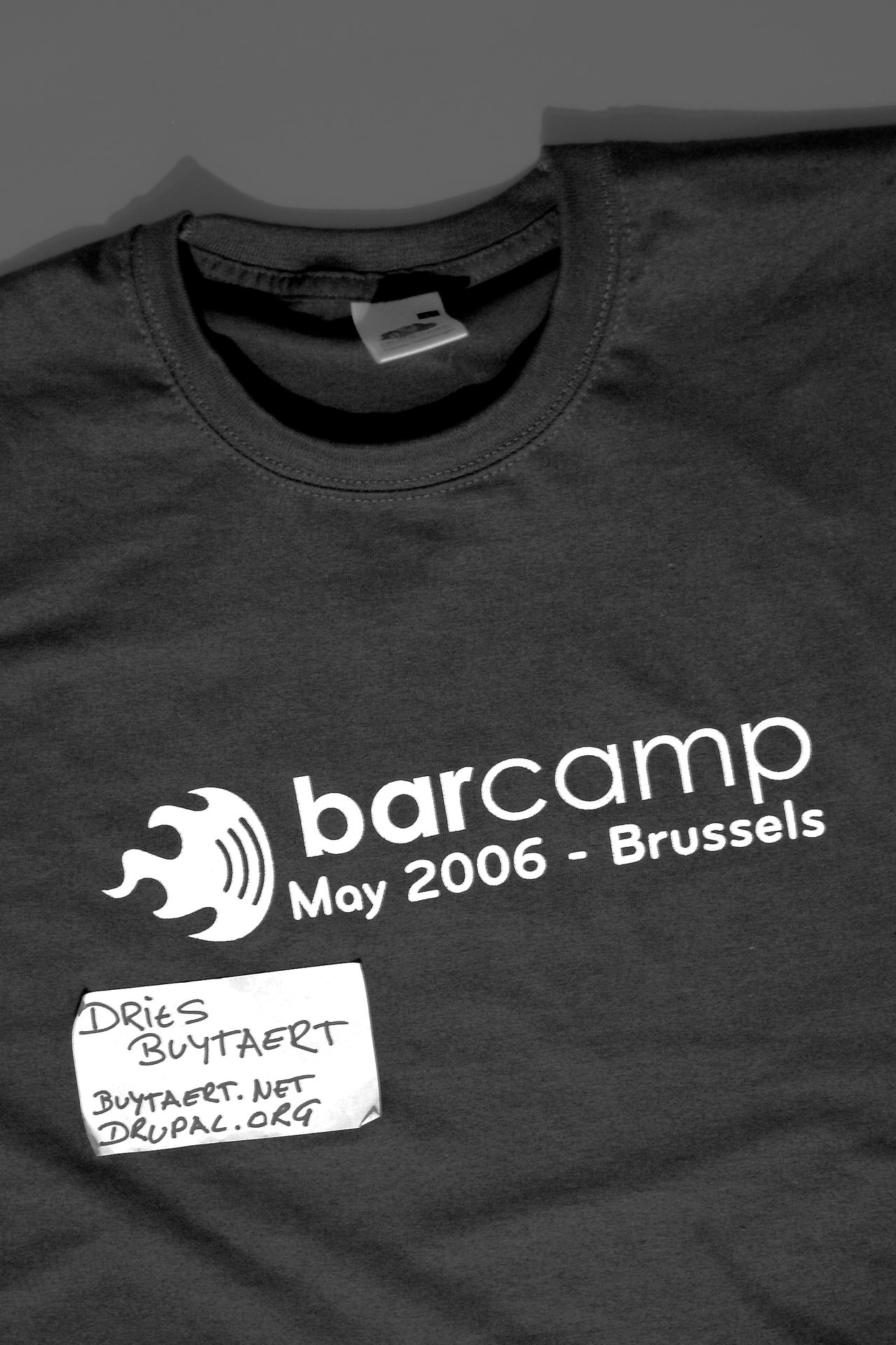 Black T-shirt with "BarCamp May 2006 - Brussels" printed on it, along with a handwritten name tag.