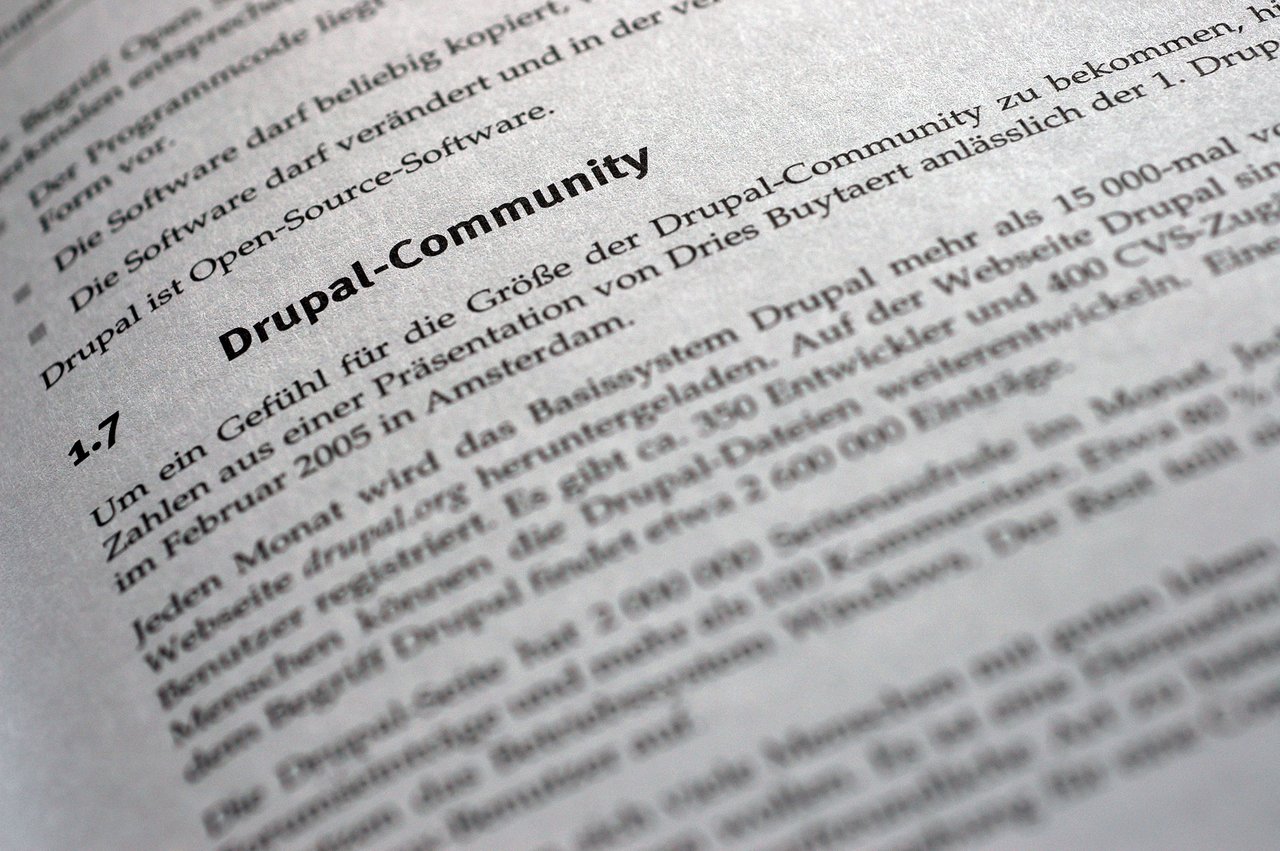 A close-up of a book page discussing the Drupal community, with bold headings and German text about open-source software.