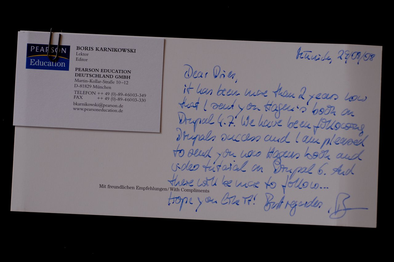 A handwritten note with a business card attached, mentioning a book and video tutorial on Drupal 6.