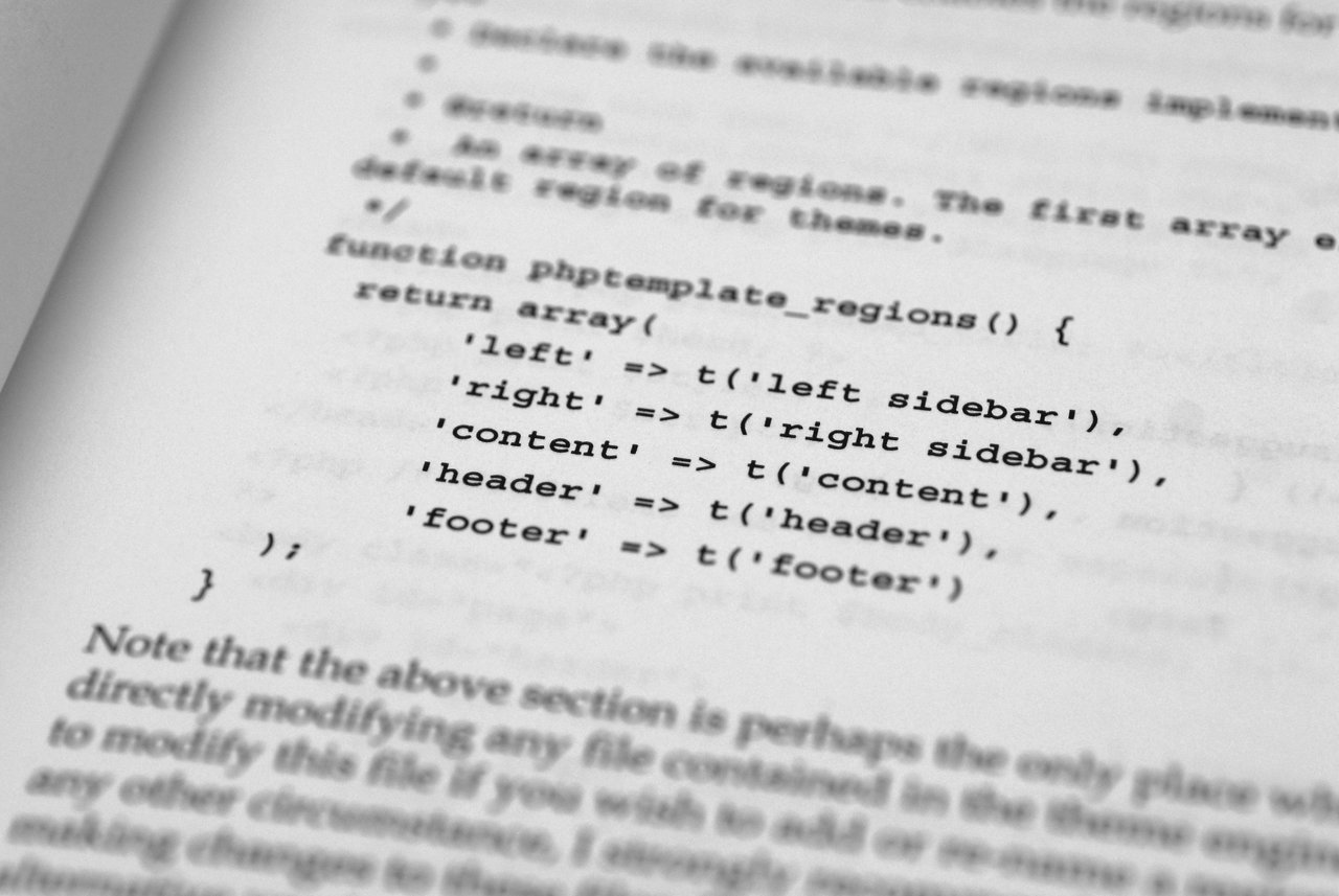 A book page showing PHP code defining theme regions for a Drupal 5 template, including sidebar, content, header, and footer.