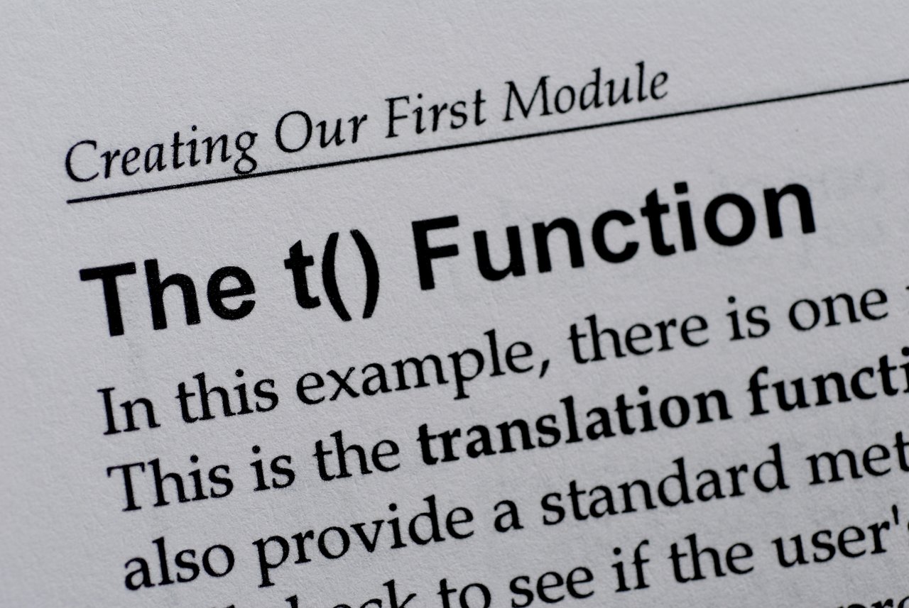 Close-up of a book page discussing the t() function in Drupal module development.