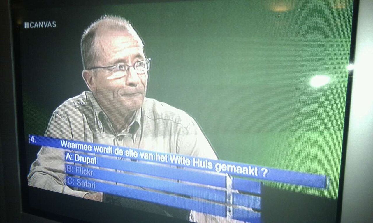 A quiz show contestant looks at the screen displaying a question about the White House website, with "Drupal" as an option.
