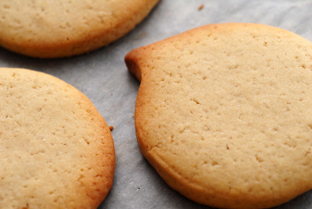 Freshly baked cookies resting on a baking sheet after being taken out of the oven.