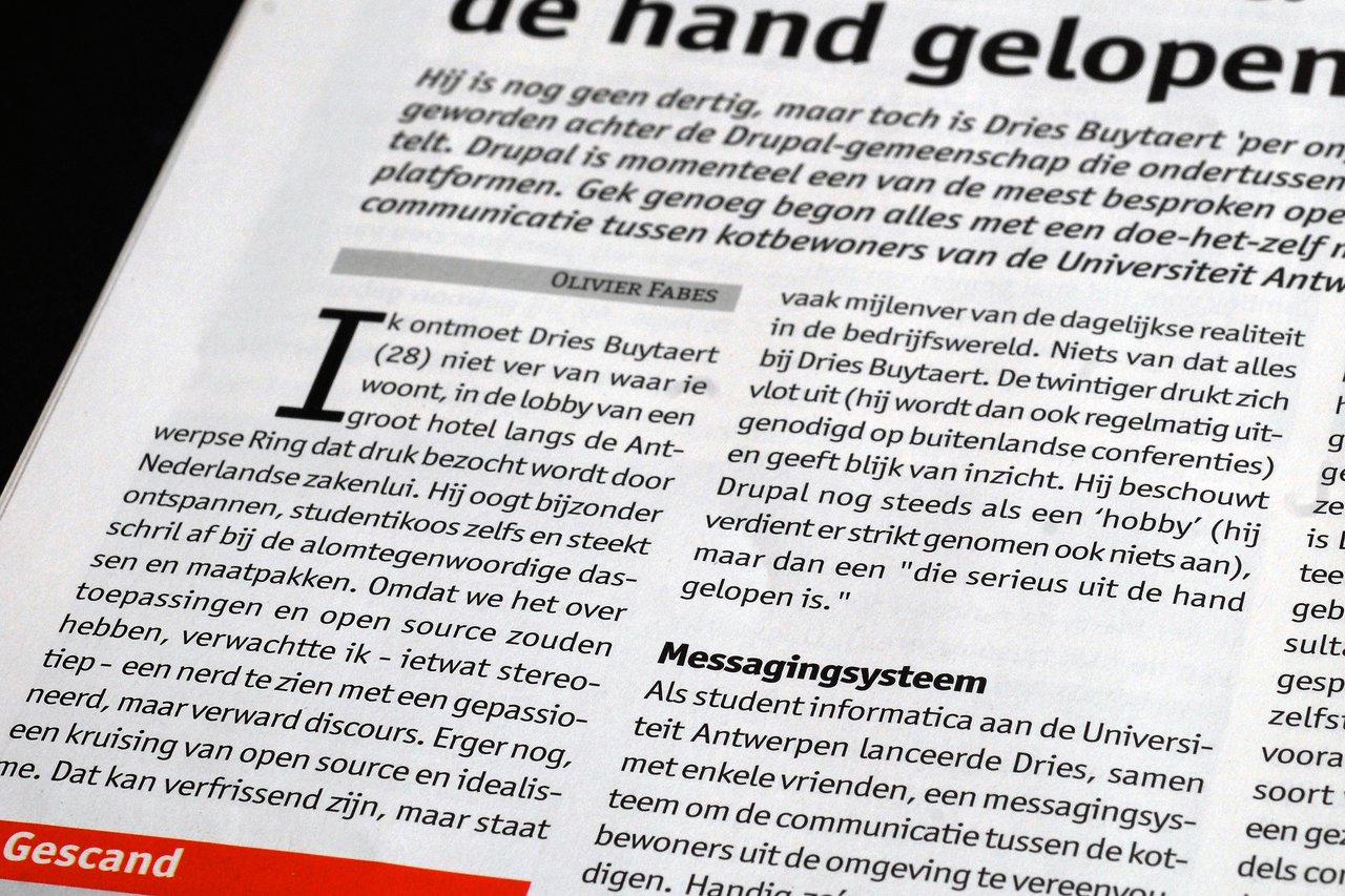 A printed article in Dutch discusses Dries Buytaert and the development of the Drupal platform.