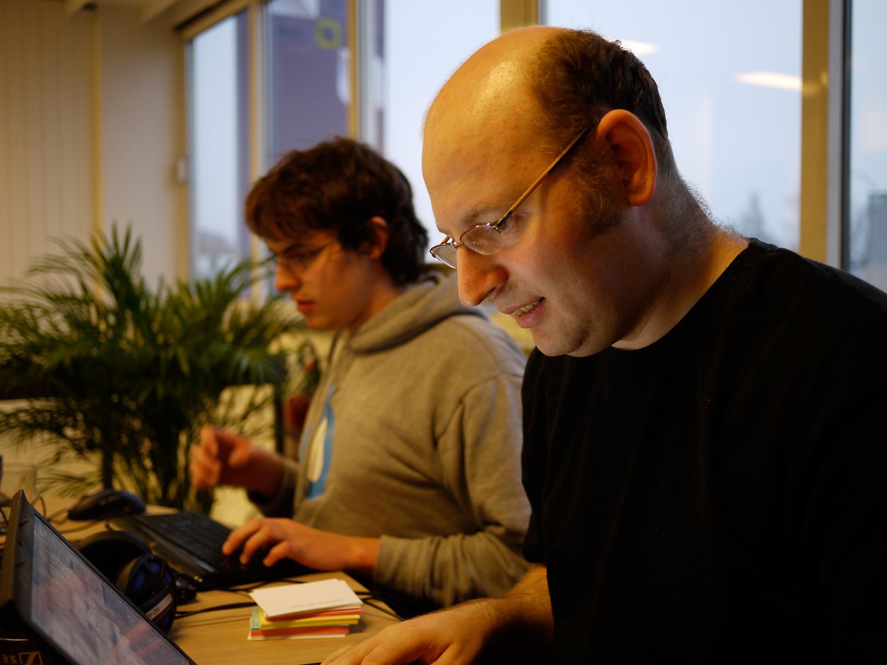 Two people working on laptops during a Drupal code sprint at Fosdem.
