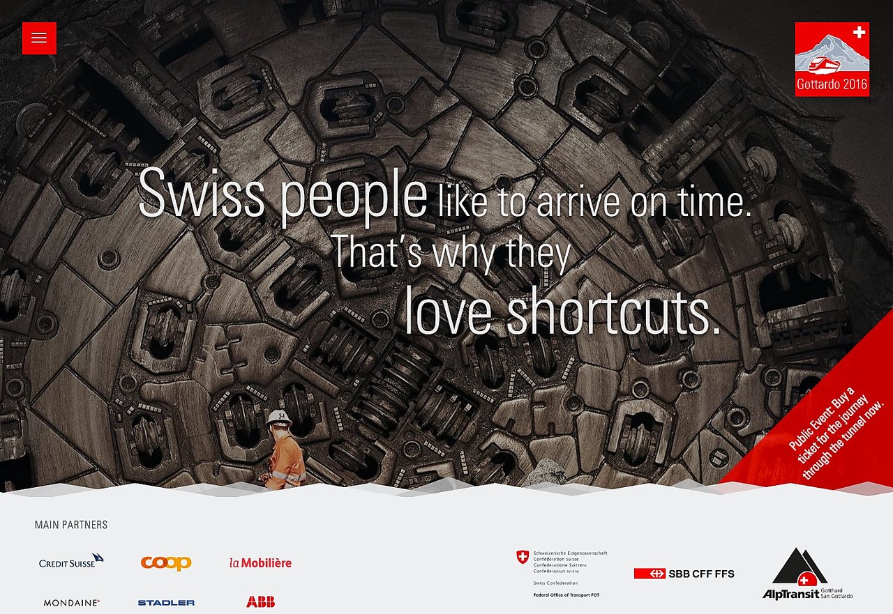 A worker in an orange uniform stands in front of a large tunnel boring machine with Swiss tunnel promotion text.