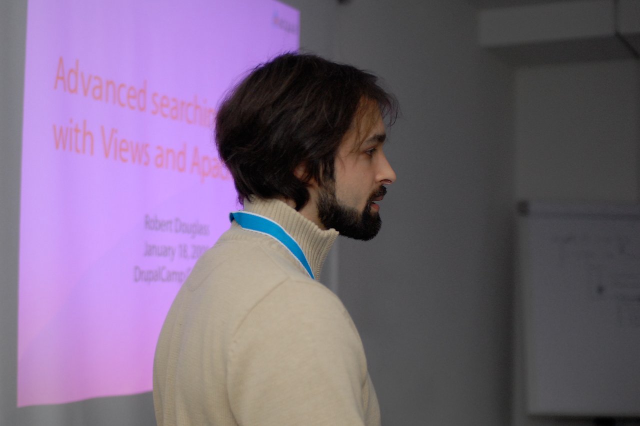 A speaker presents on Apache Solr and search technology at DrupalCamp Cologne 2009, with a projected slide behind him.