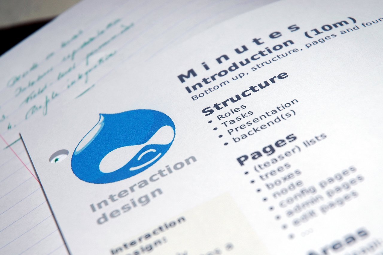 Close-up of printed Drupal usability meeting minutes with a blue Drupal logo and handwritten notes on lined paper.