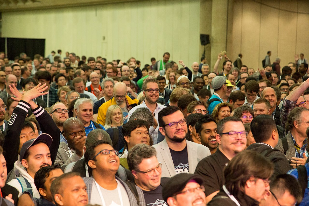 A large group of Drupal community members gathers at DrupalCon Baltimore 2017, smiling and cheering.