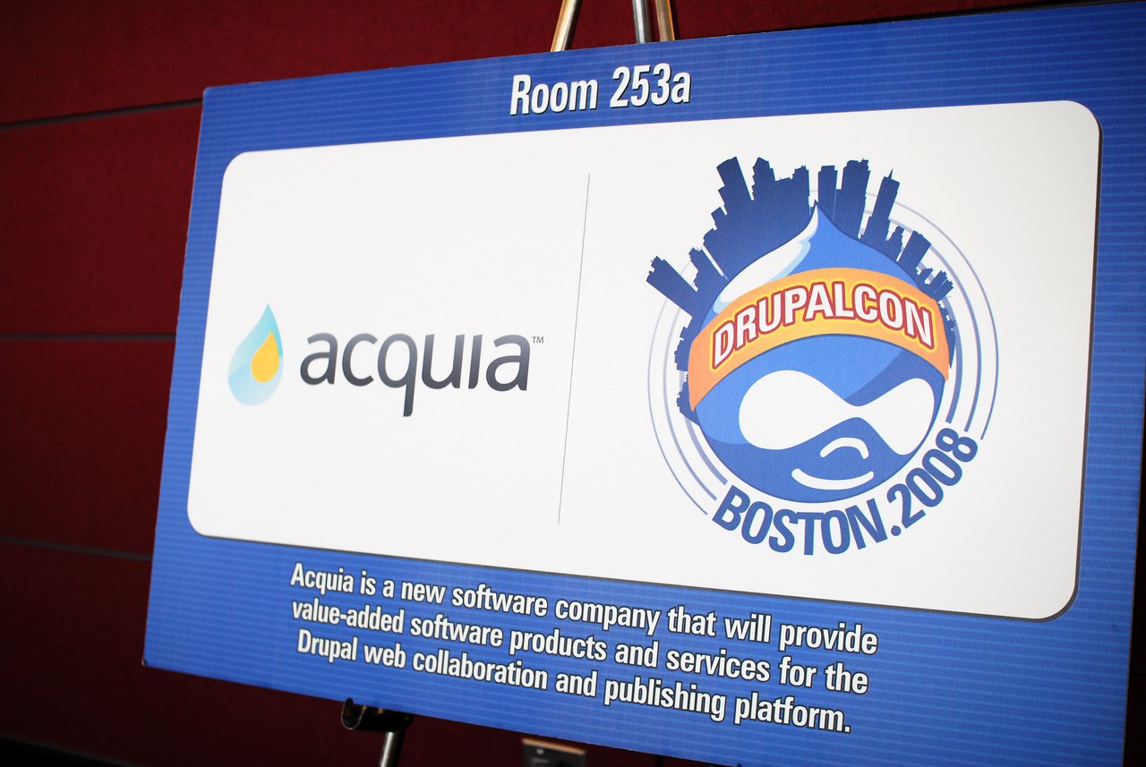 Sign displaying Acquia branding and DrupalCon Boston 2008 logo, describing Acquia as a new software company for Drupal services.