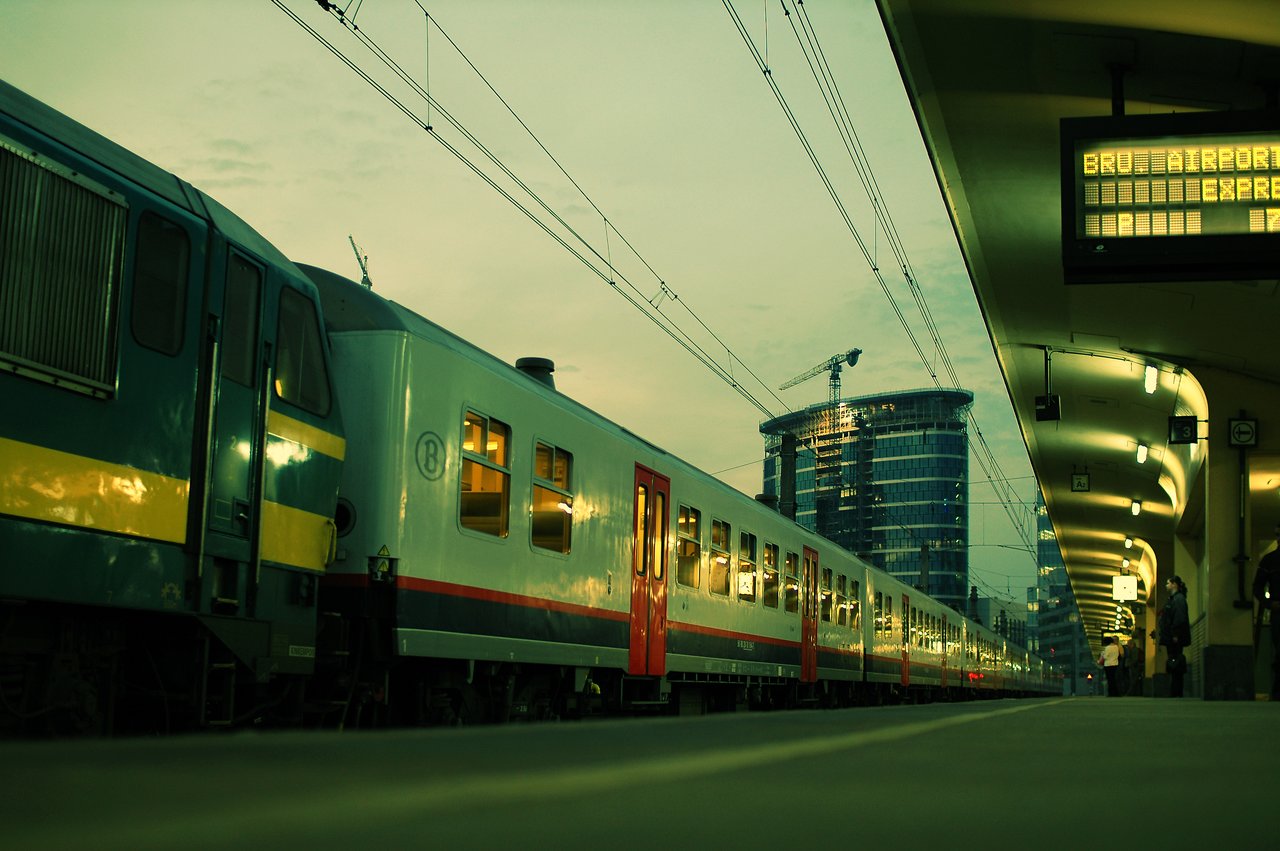 A train labeled "Airport Express" is stopped at a platform, with passengers waiting nearby.