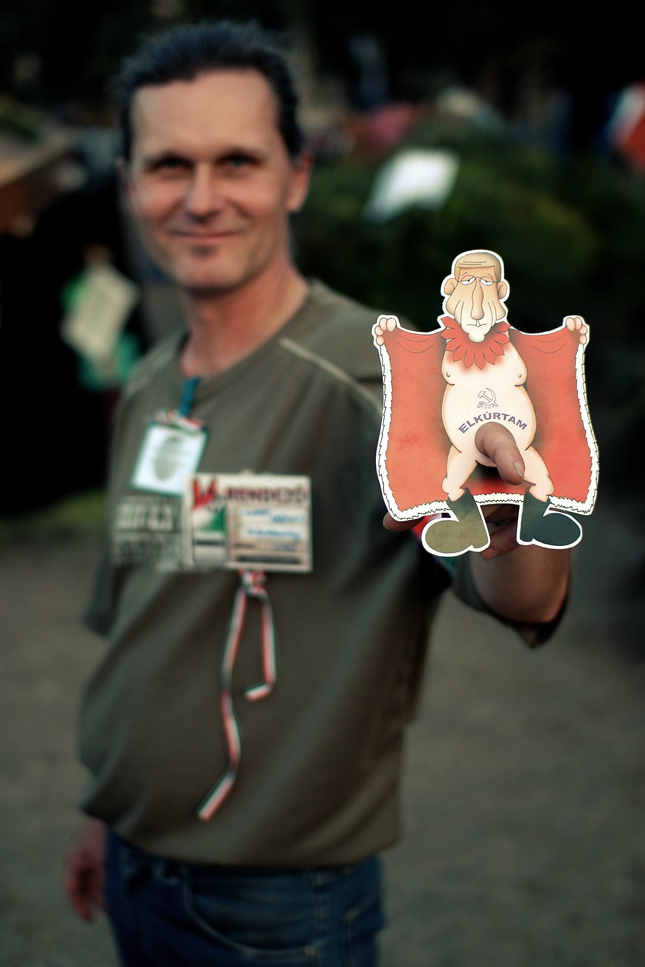A man holds up a satirical cartoon cutout with a political message during a peaceful protest.