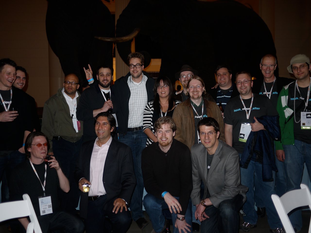 A group of people posing together at DrupalCon Chicago 2011, some wearing event badges and branded shirts.