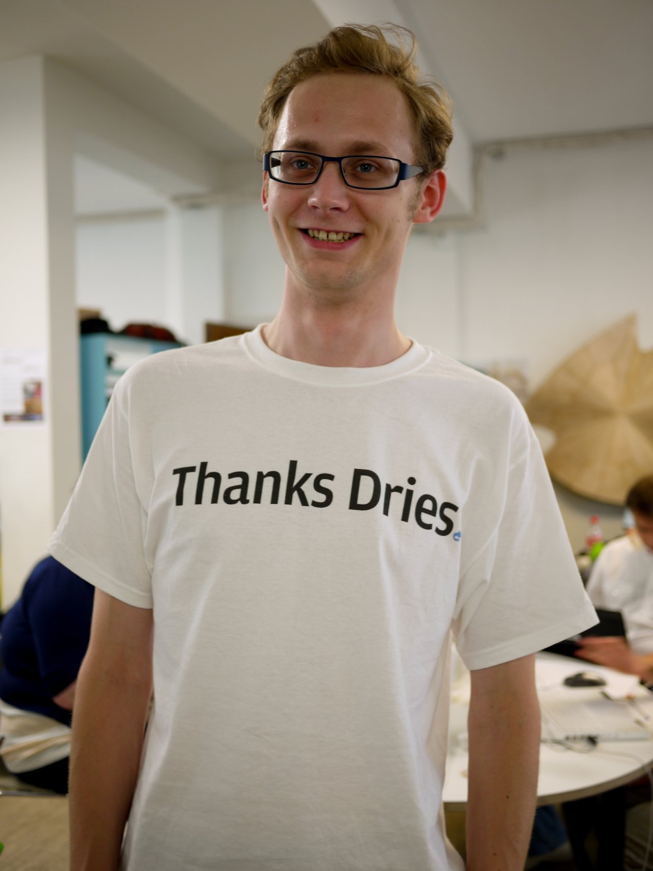 A smiling person wearing a white t-shirt with "Thanks Dries" printed on it at DrupalCon Copenhagen 2010.