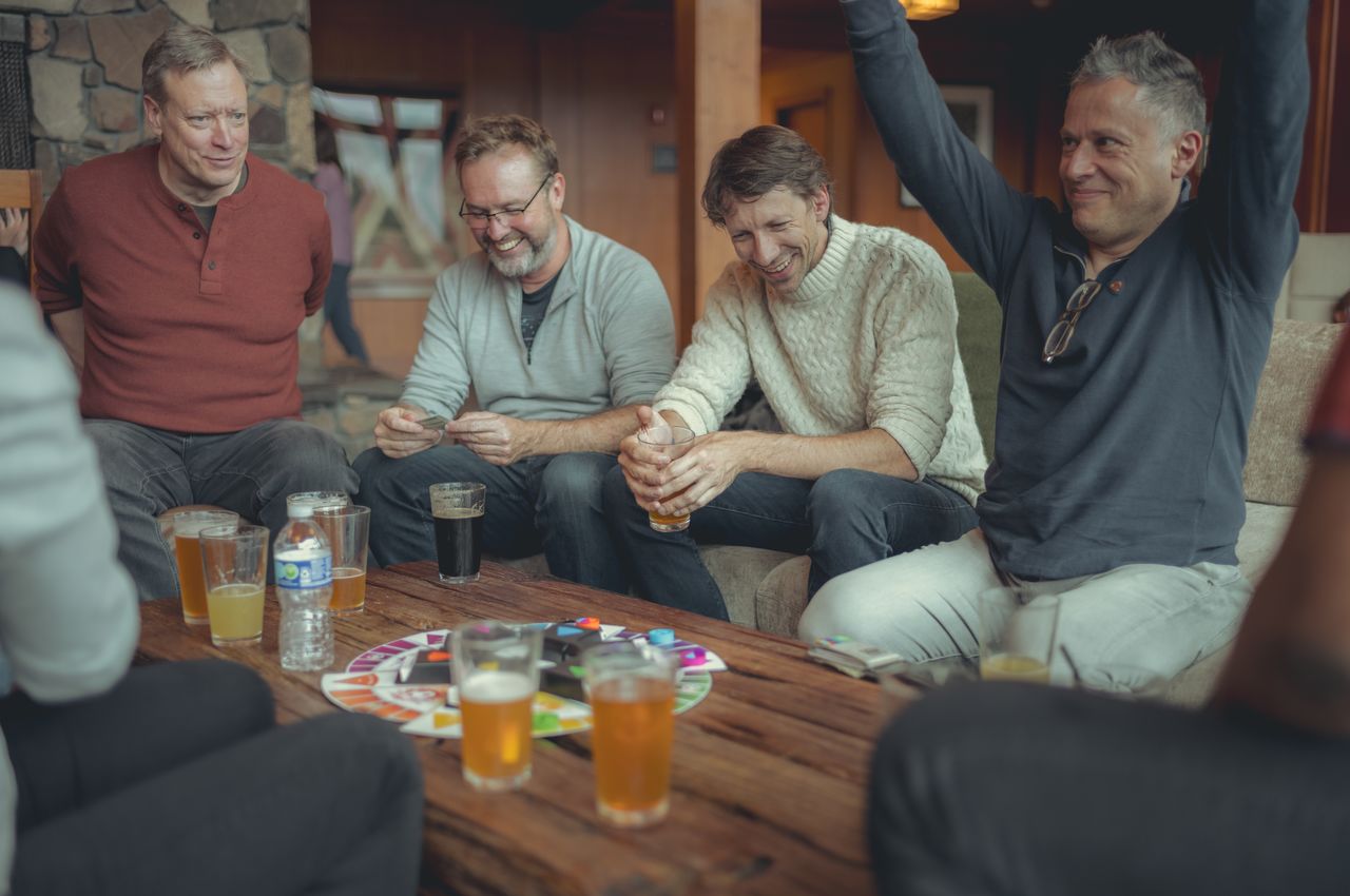 People seated around a table playing a board game.