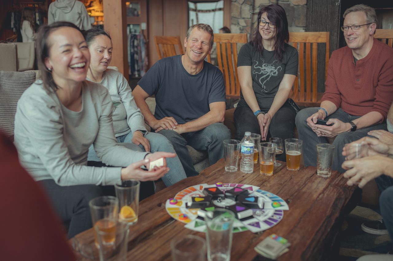 People seated around a table playing a board game.