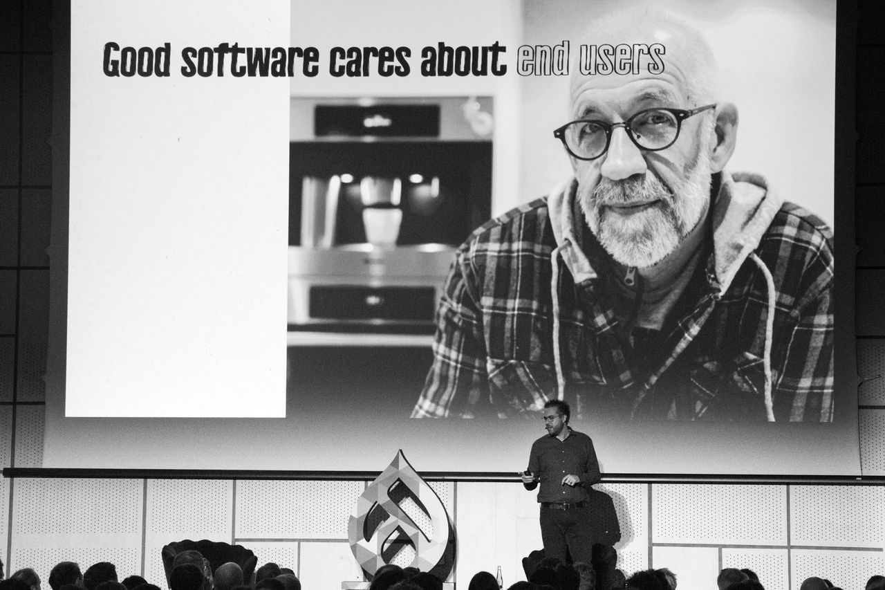 Dries delivering his keynote at DrupalCon Prague. The slide in the background reads 'Good software cares about end users'.