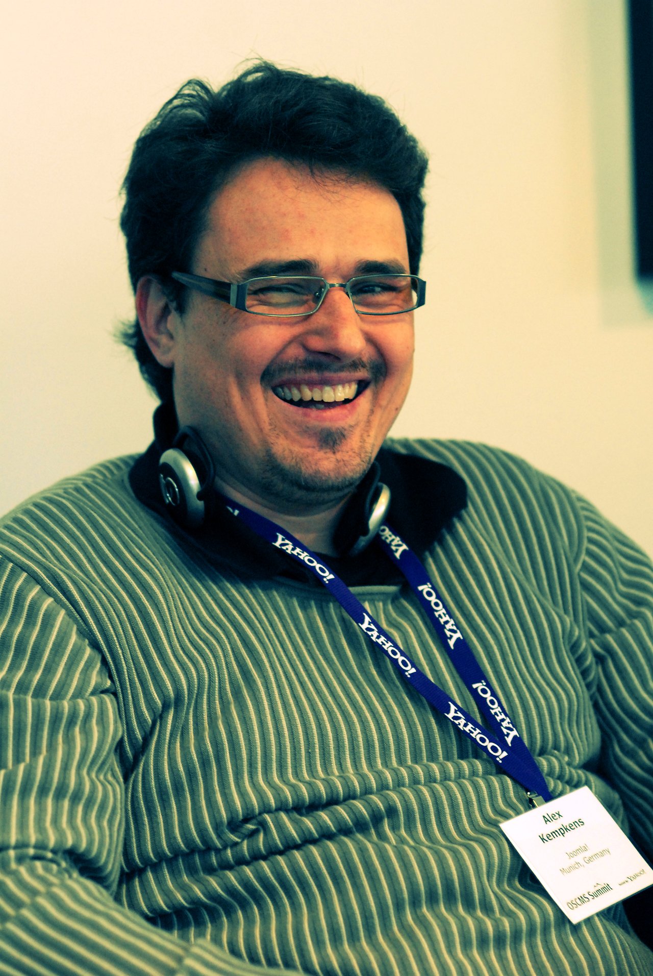 A smiling man wearing glasses, headphones, and a Yahoo! lanyard at DrupalCon Sunnyvale 2007.