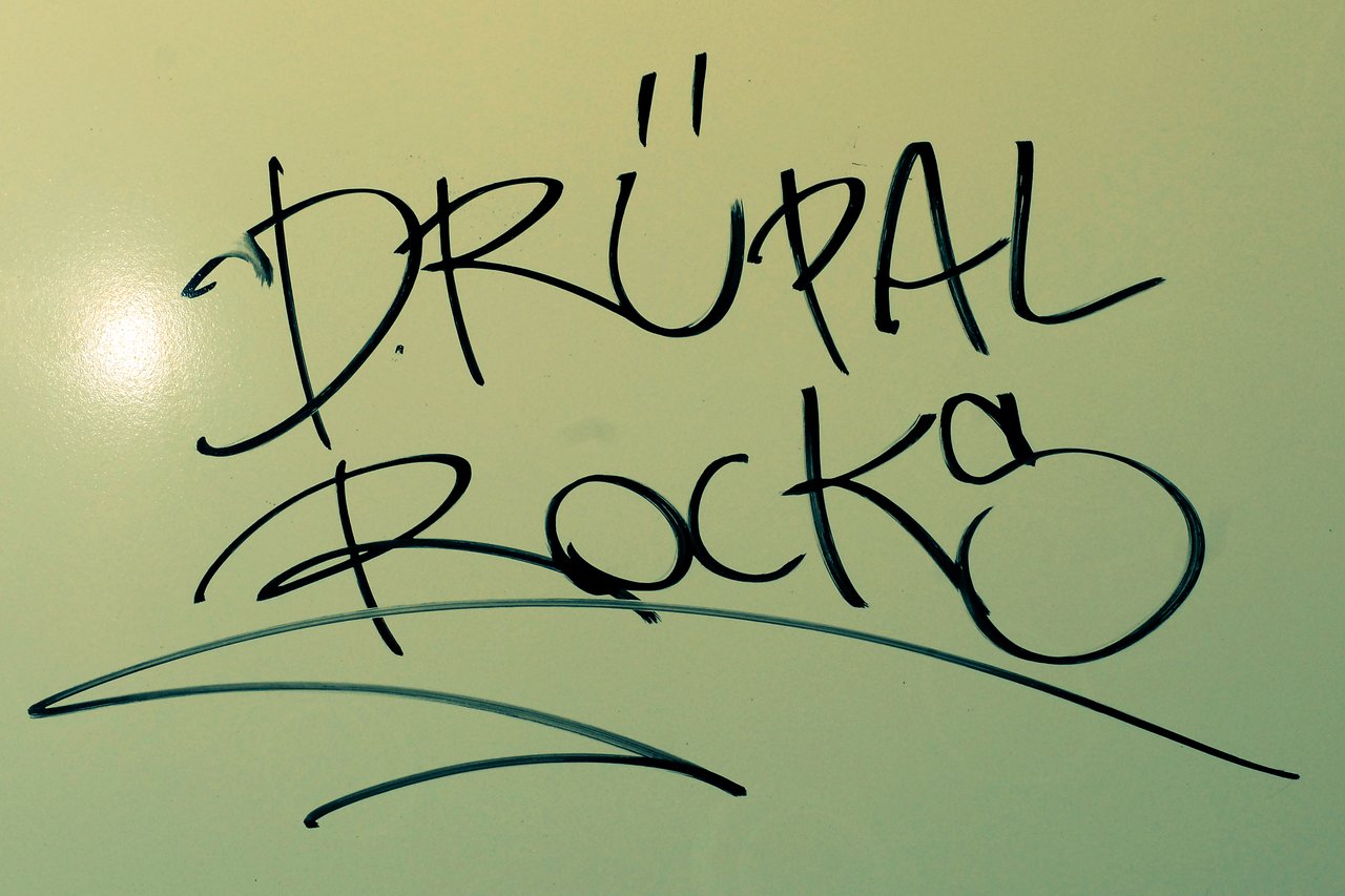 Black marker graffiti-style text on a whiteboard reads "Drupal Rocks" with decorative underlines.