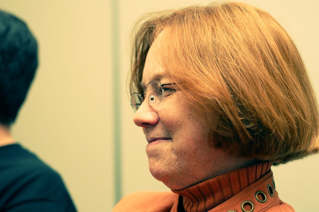 A woman with glasses and short red hair smiles while looking to the side at DrupalCon Sunnyvale 2007.