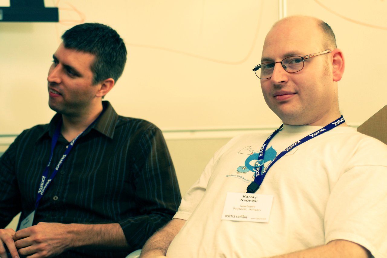 Two men wearing conference badges sit and listen during a discussion at DrupalCon Sunnyvale 2007.
