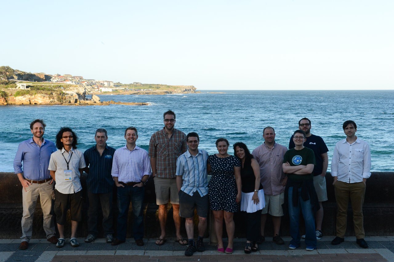 A group of people posing together in front of the ocean at DrupalCon Sydney 2013.