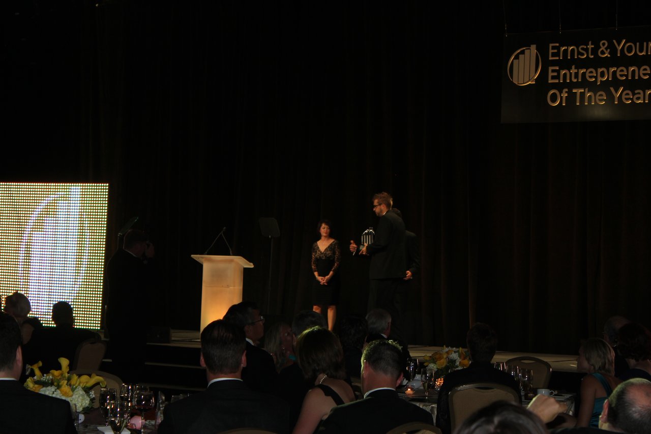 A person on stage receives an award at the Ernst &amp; Young Entrepreneur of the Year banquet.