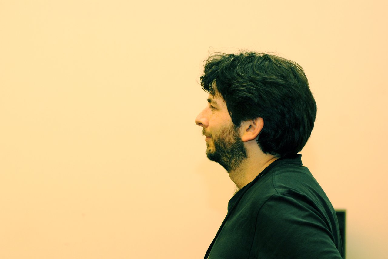 A man in a black shirt speaks while presenting a Photosynth demo at FooCamp 2007.
