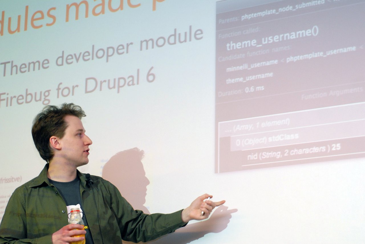 A presenter explains new features in Drupal 6, pointing at a slide about the theme developer module.
