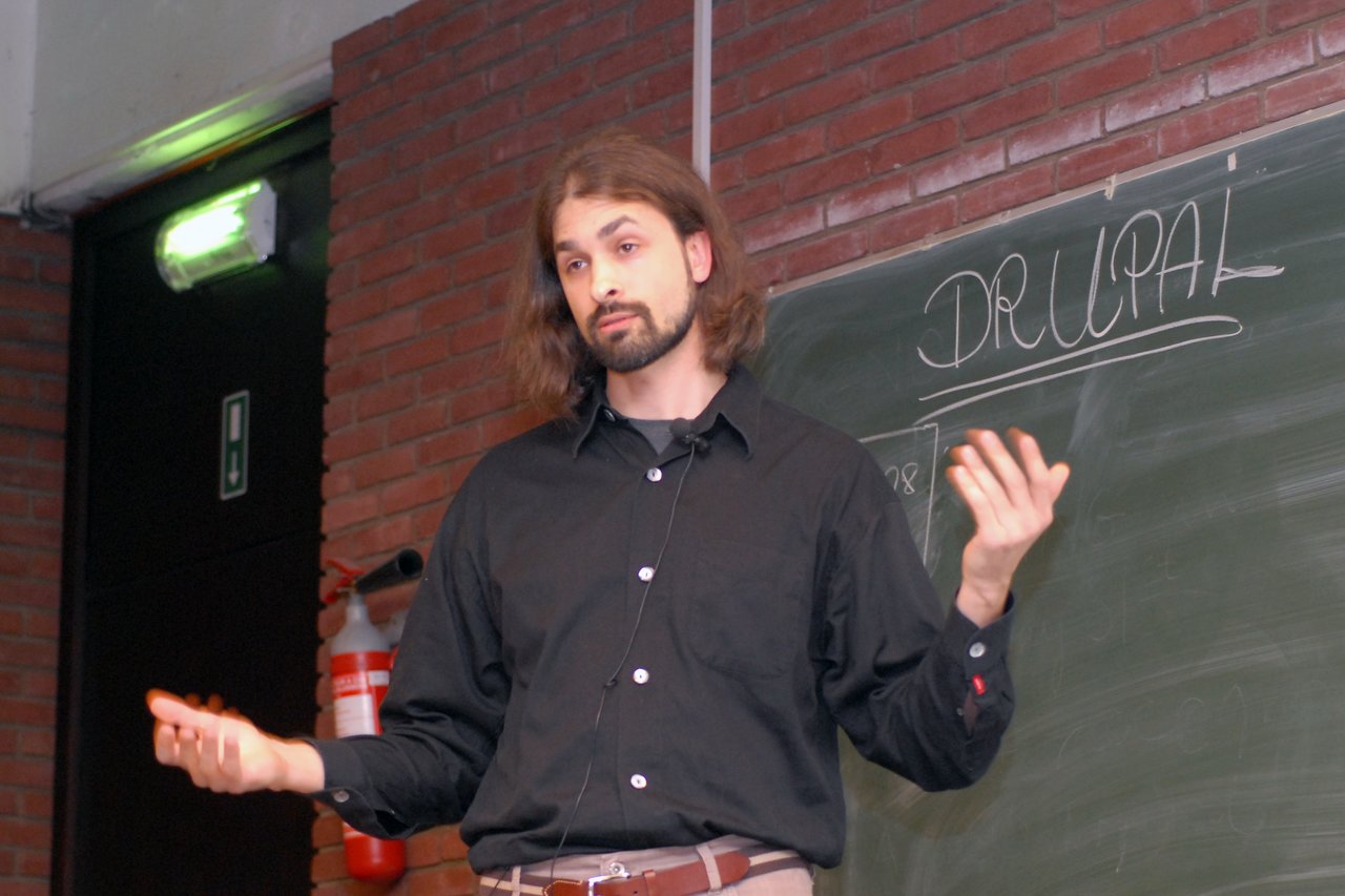 A speaker gives a presentation about the Solr module for Drupal at FOSDEM 2008, standing in front of a chalkboard.