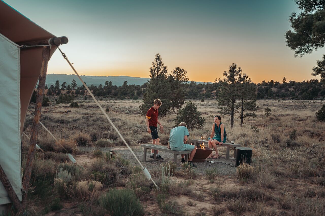A family sits around a fire pit at a campsite in the high desert outside Bryce, Utah.